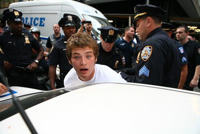 Protester Charlie Meyers is arrested during the afternoon march